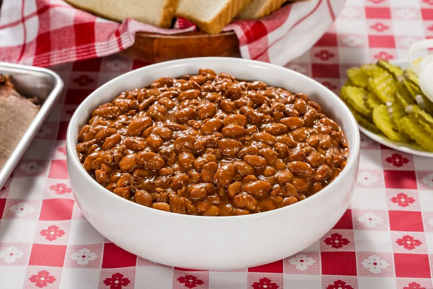 Bowl of baked beans on a red checkered picnic tablecloth
