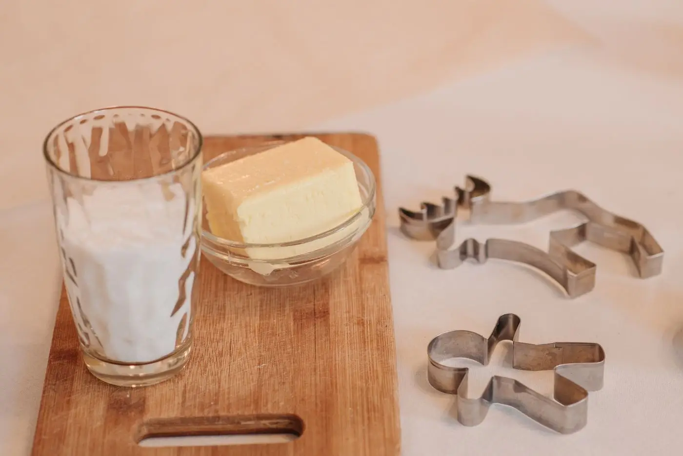 Block of butter in a small glass bowl on a wooden cutting board