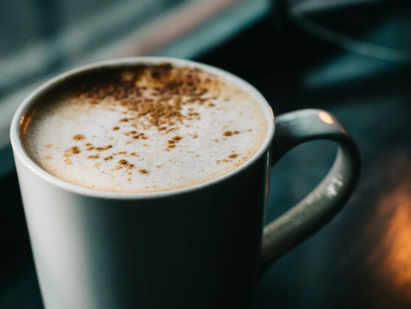 Creamy spiced chai latte dusted with cinnamon in a white mug