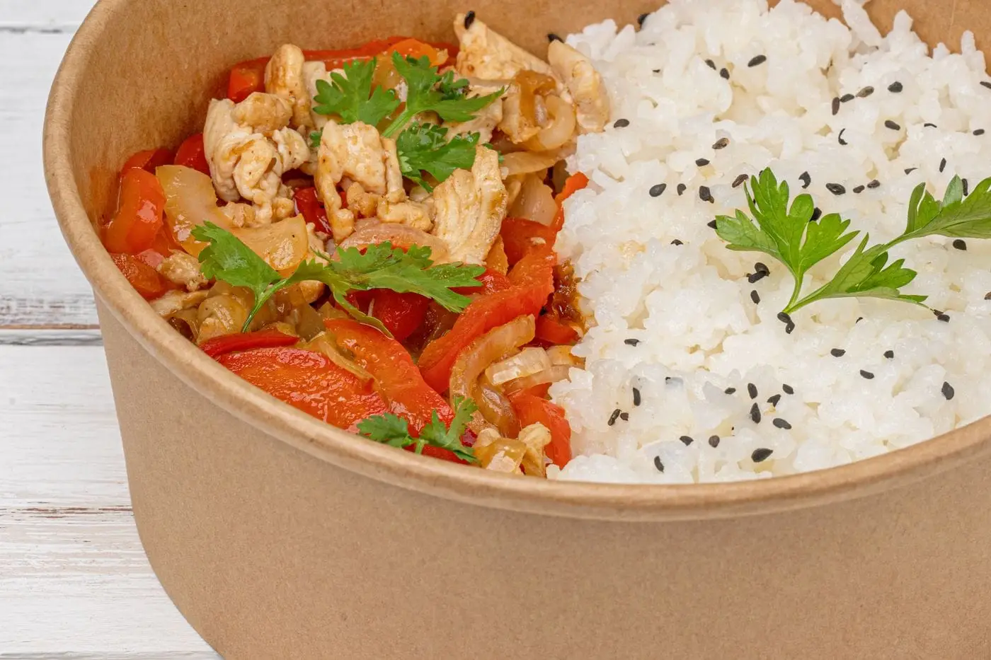 Bowl of white rice with sautéed chicken, red peppers and parsley