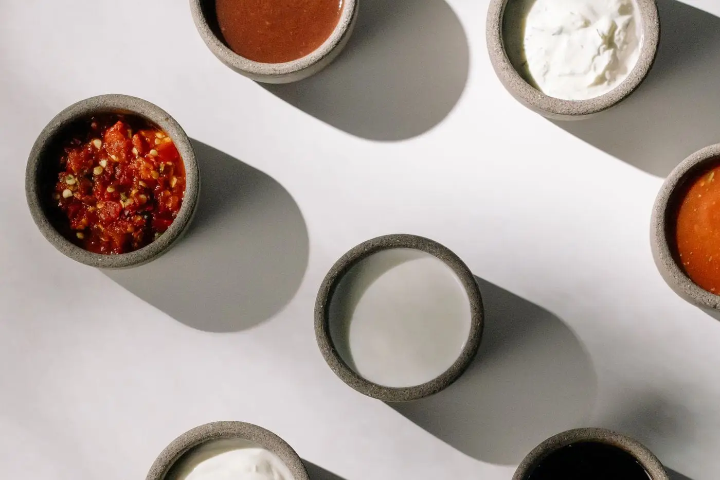 Top view of small stoneware bowls holding assorted dipping sauces
