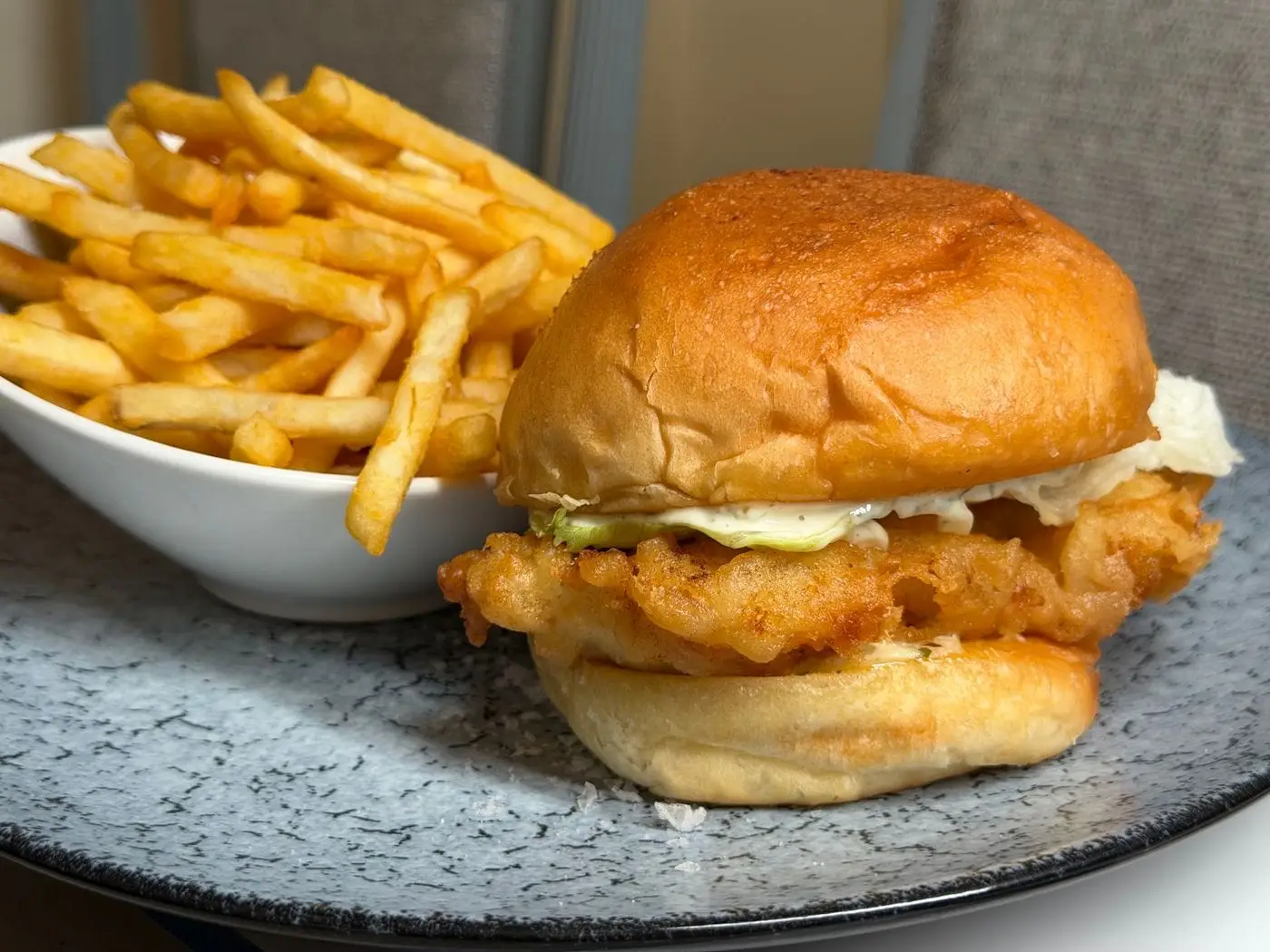Crispy fried fish fillet sandwich on a soft bun with fries