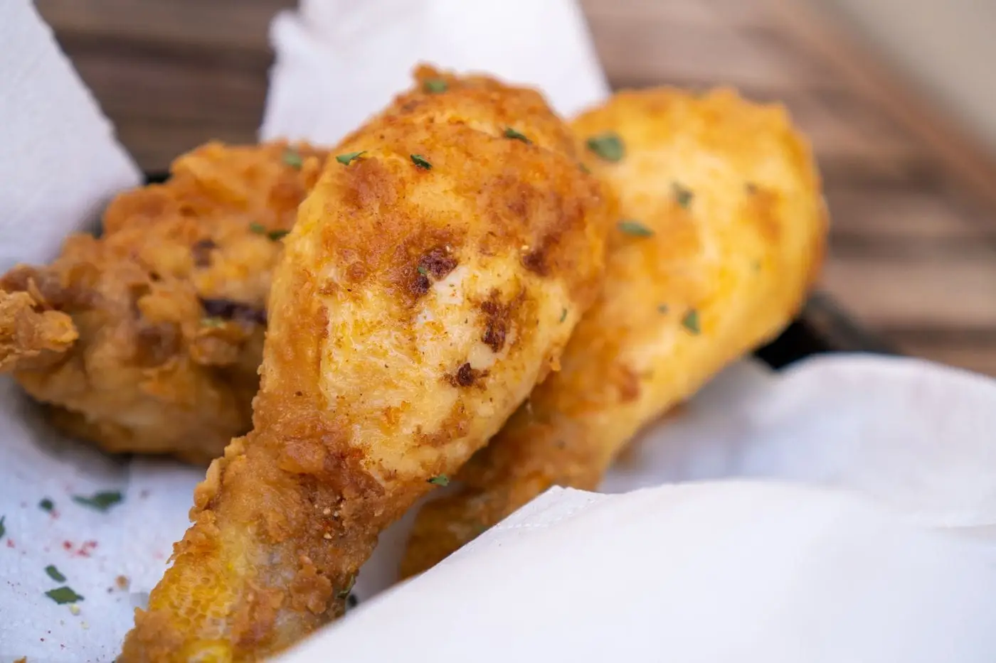 Golden crispy fried chicken drumsticks on paper towel