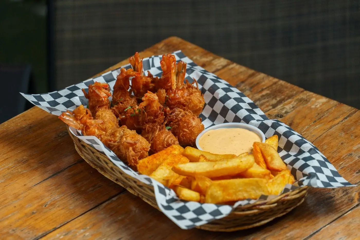 Basket of golden fried shrimp and fries with dipping sauce