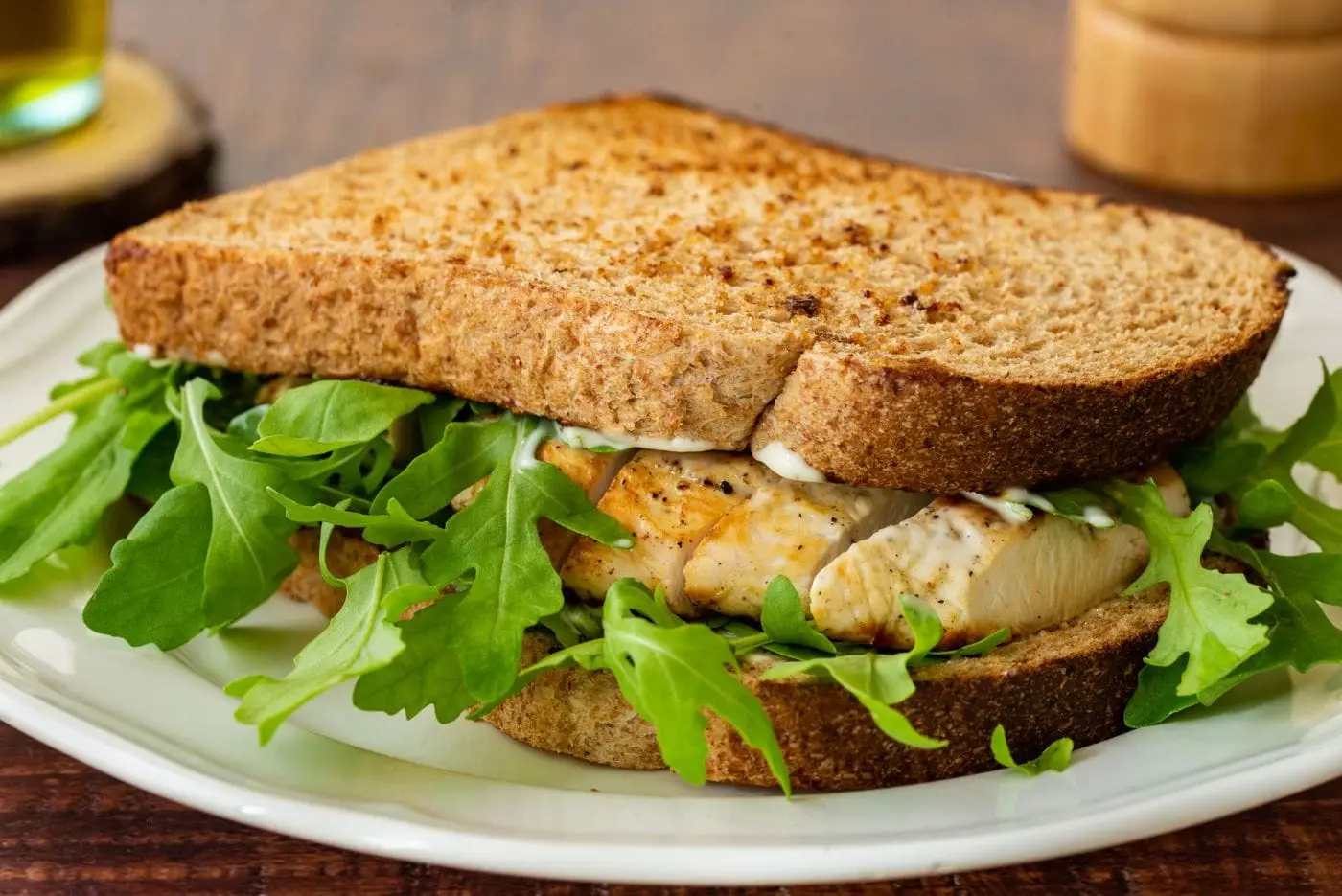 Grilled chicken sandwich with arugula and mayonnaise on toasted wheat bread