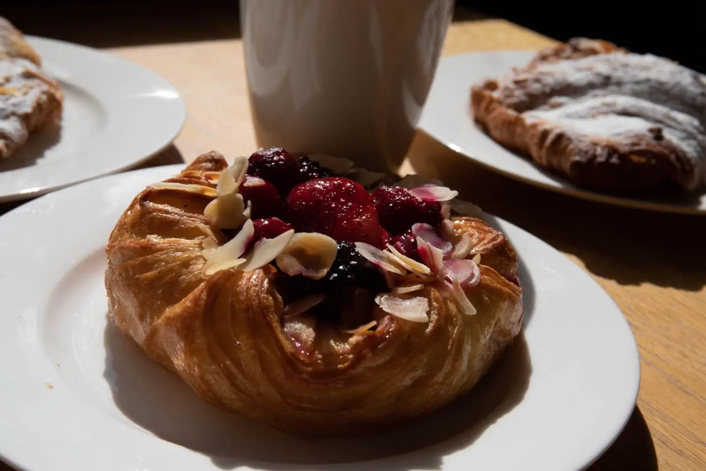 Flaky danish pastry topped with mixed berries and sliced almonds