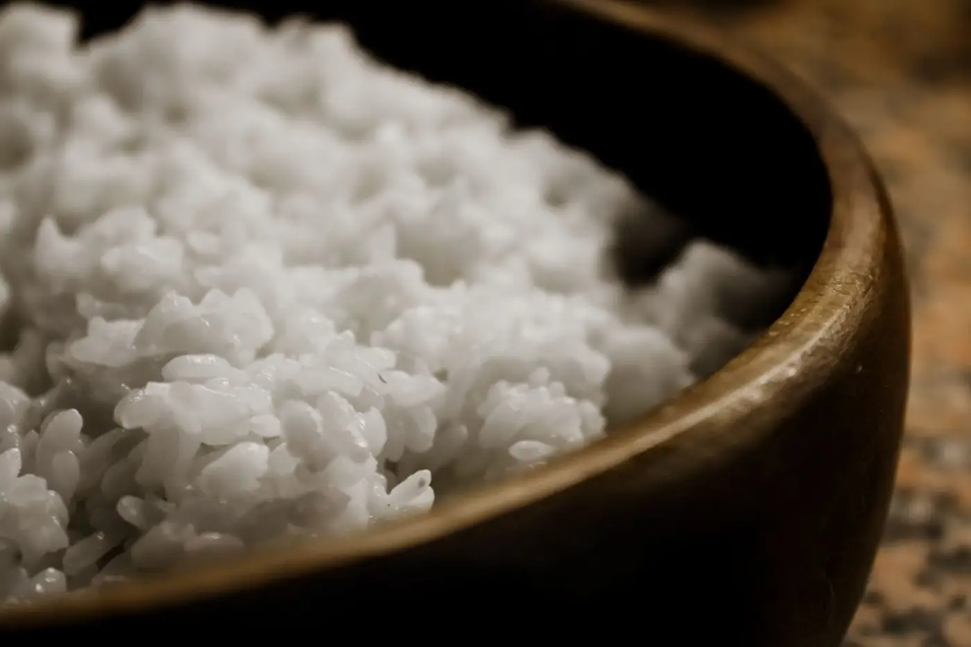 Close-up of fluffy steamed white rice in a wooden bowl