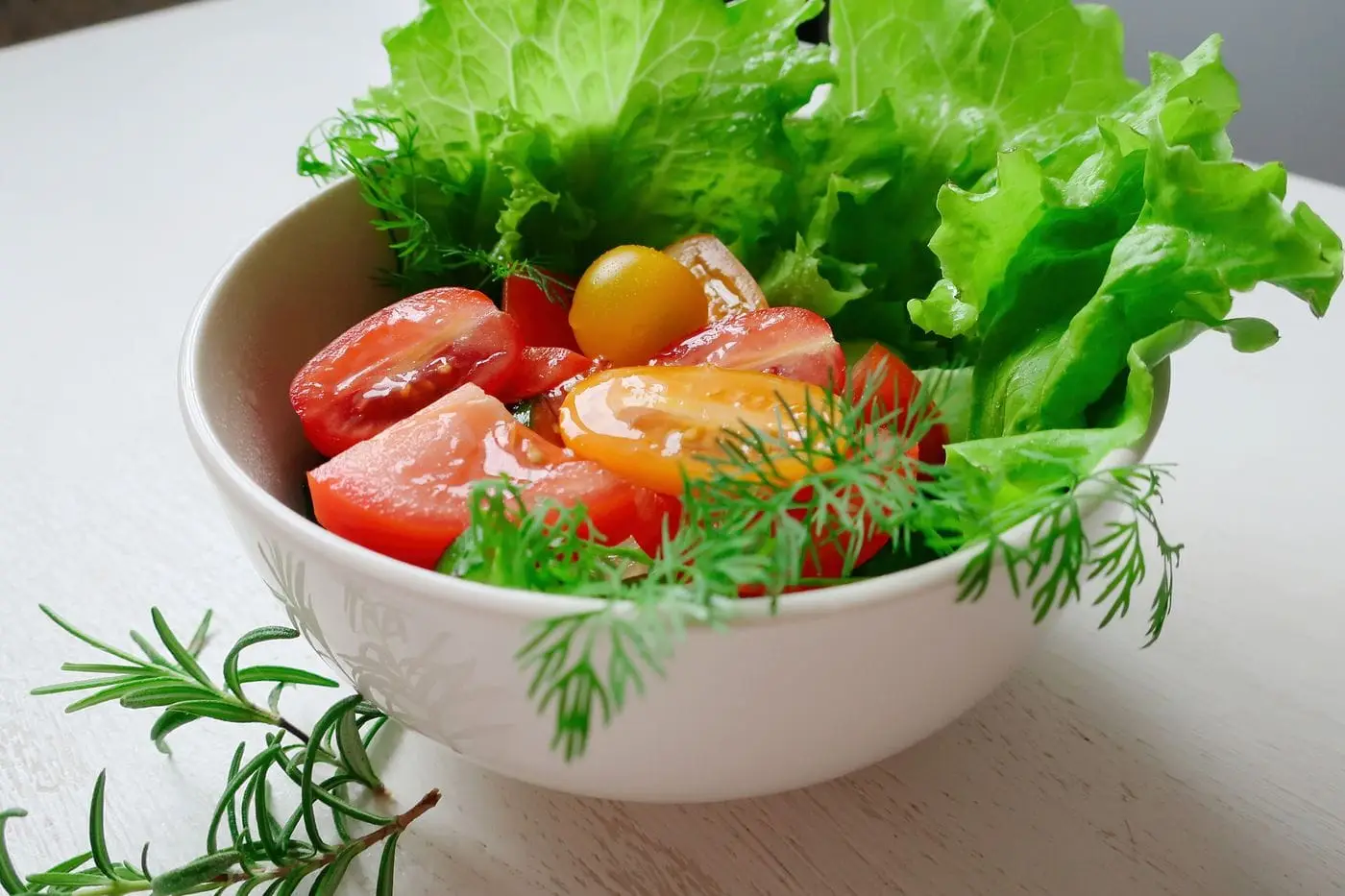 Small green salad with lettuce, cherry tomatoes and dill in a bowl