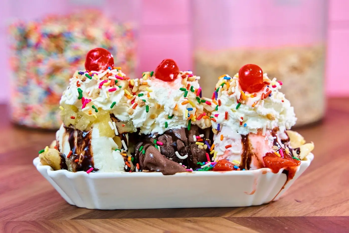 Banana split sundae with whipped cream, cherries, sprinkles and chocolate sauce